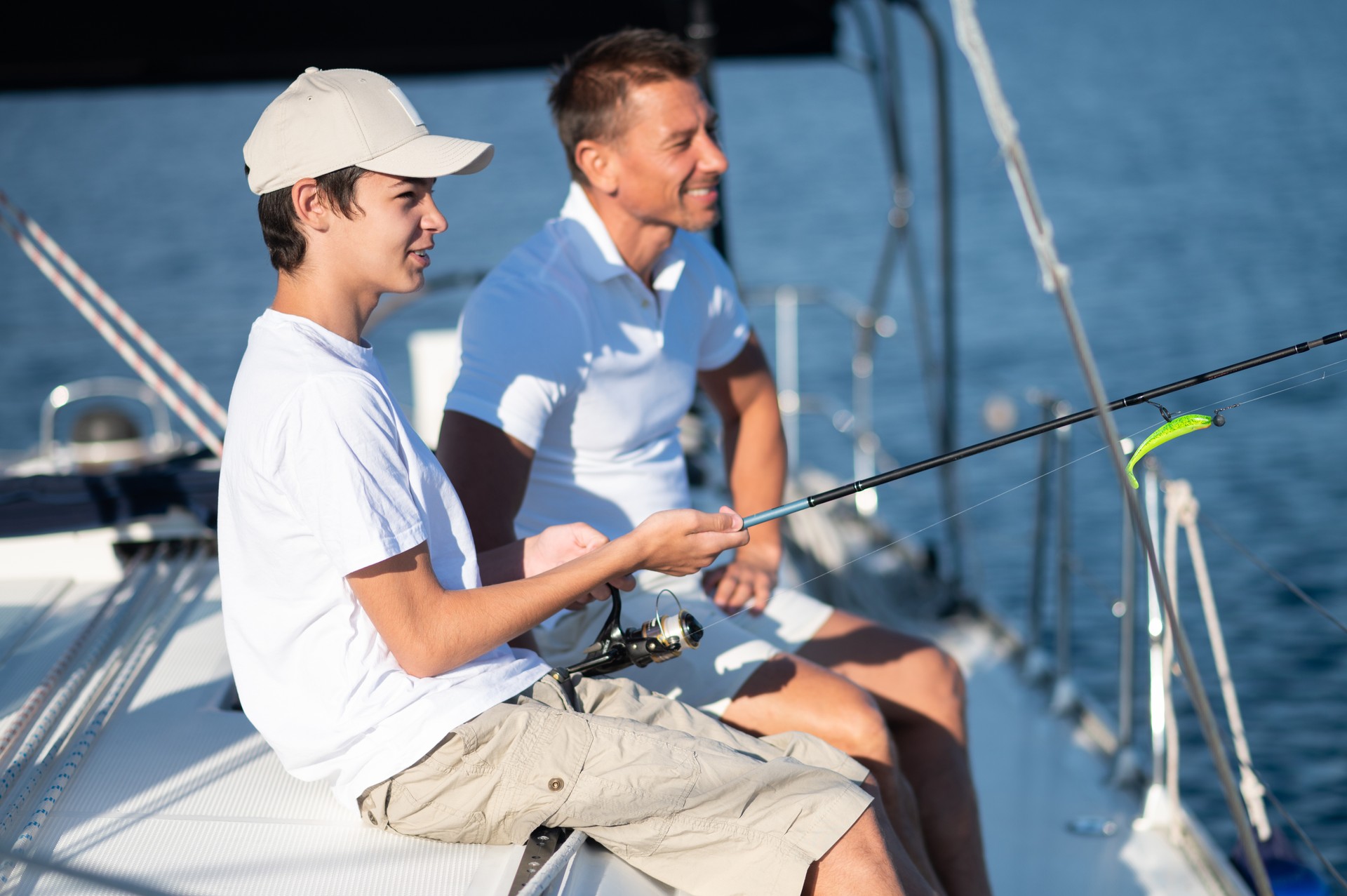 Dad and son spending time together on the yacht and fisihing